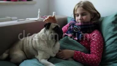 生病的小美丽的女孩带着围巾和她的狗在床上。 女孩身边有<strong>药品</strong>：喷鼻剂